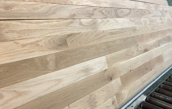 Unfinished White Oak #1 Common Solid Hardwood Flooring. Closeup on a green shooting table. 
