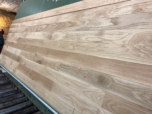 Unfinished White Oak #1 Common Solid Hardwood Flooring. Closeup on a green shooting table. 