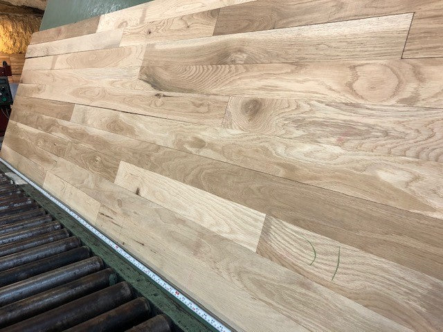 Unfinished White Oak #1 Common Solid Hardwood Flooring. Closeup on a green shooting table. 