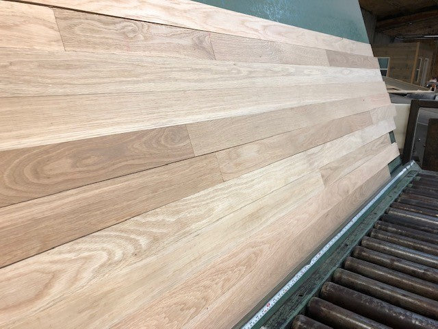 Unfinished White Oak Select & Better Solid Hardwood Flooring shown on a green shooting table. Steep left hand shot.
